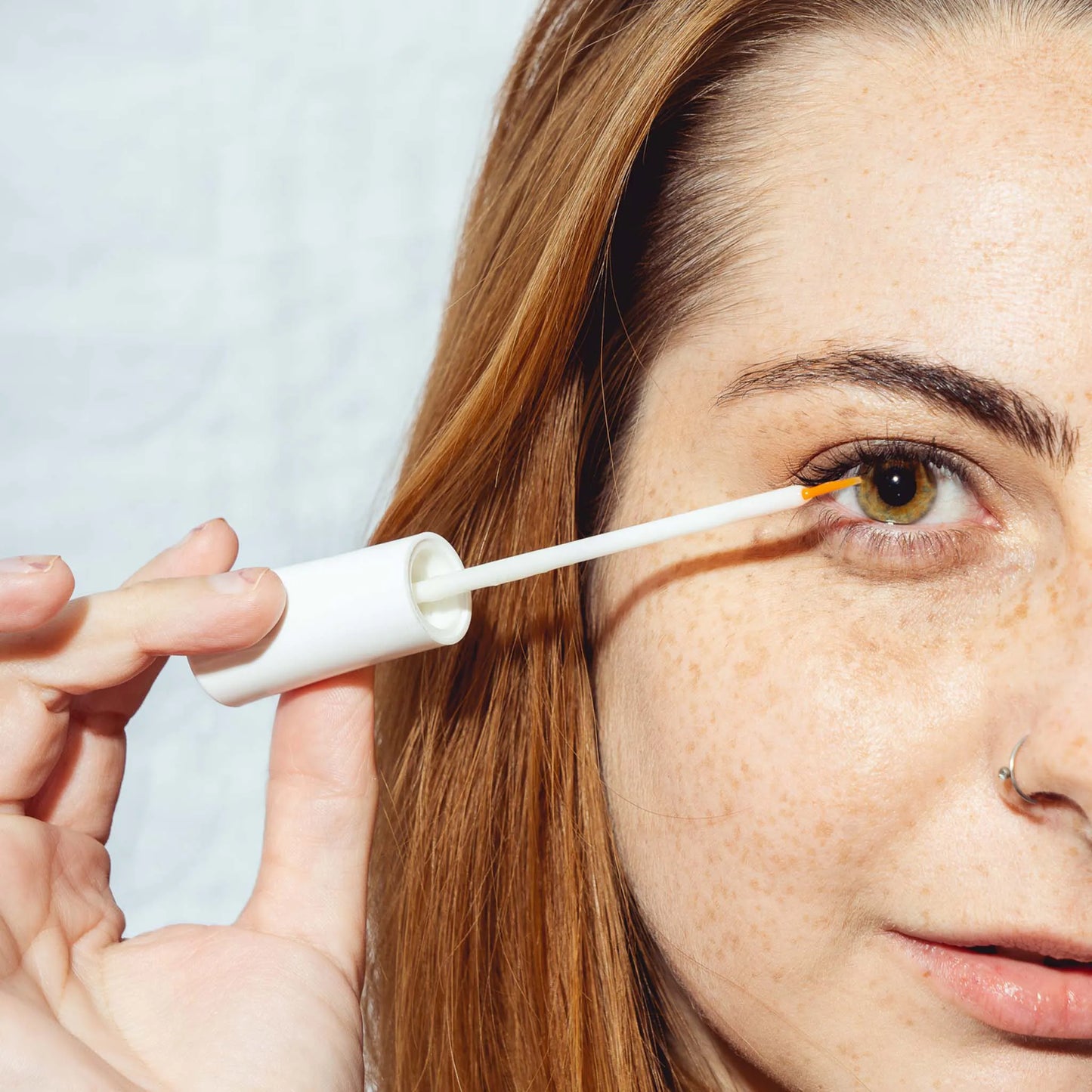 een vrouw houdt het serum voor haar oog