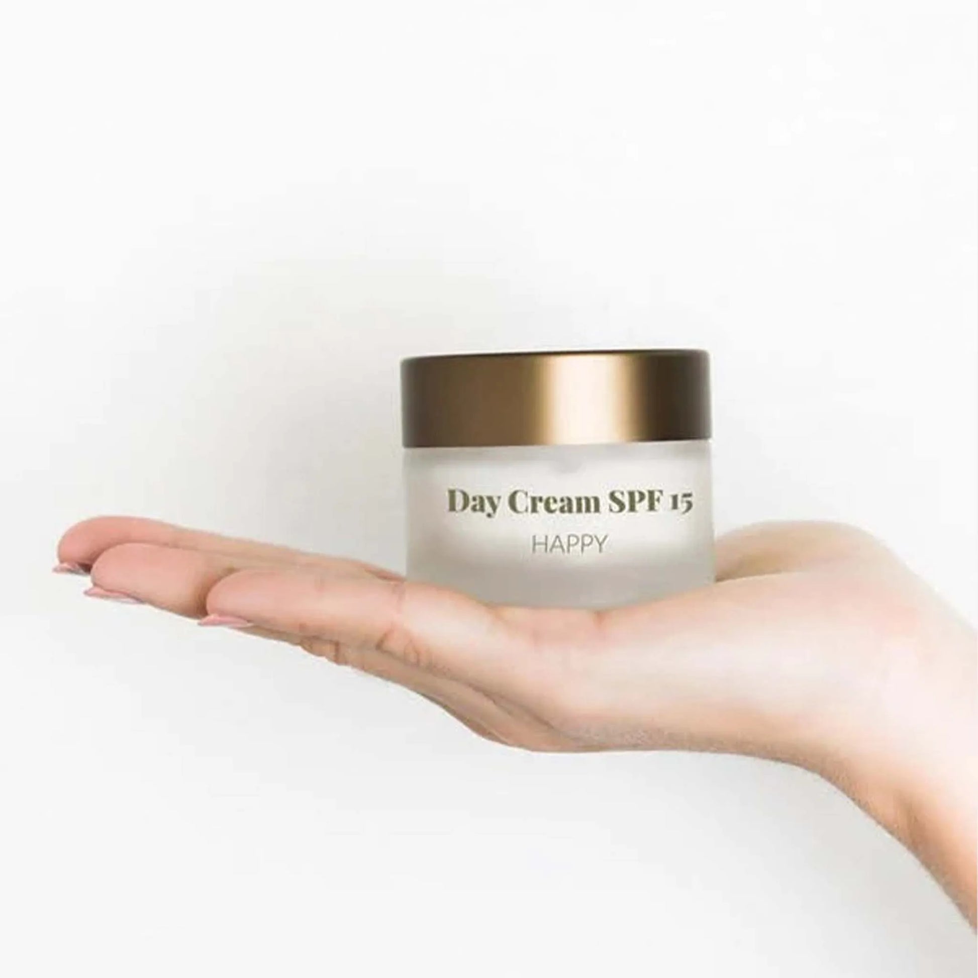 Het doosje van Nordic Cosmetics Dagcrème ligt op de handpalm van een vrouw.