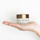 Het doosje van Nordic Cosmetics Dagcrème ligt op de handpalm van een vrouw.