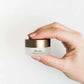 Een vrouwenhand houdt de doos Nordic Cosmetics Oogcrème vast.
